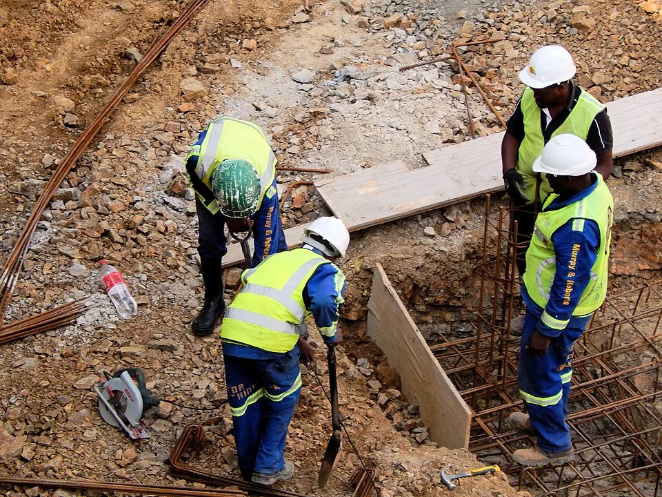 Equipa de obra com capacete e colete refletor